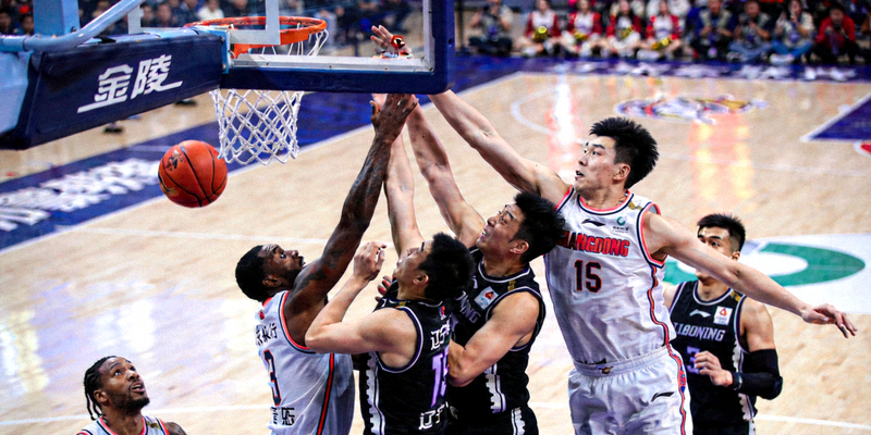 CBA总决赛广东队与辽宁队比赛中，球员在篮下激烈卡位争抢篮板球